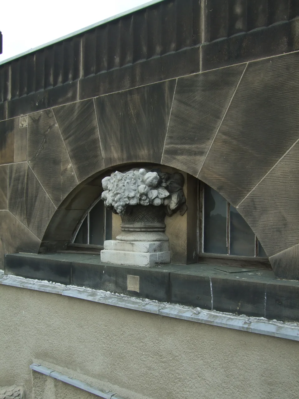 Bogen mit Blumenkorb, verschwärzter Sandstein